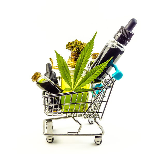 Small shopping cart filled with CBD products and cannabis leaf