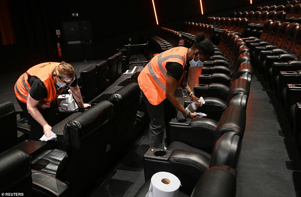 Staff members clean seats at Vue Cinema in Leicester Square during its reopening today